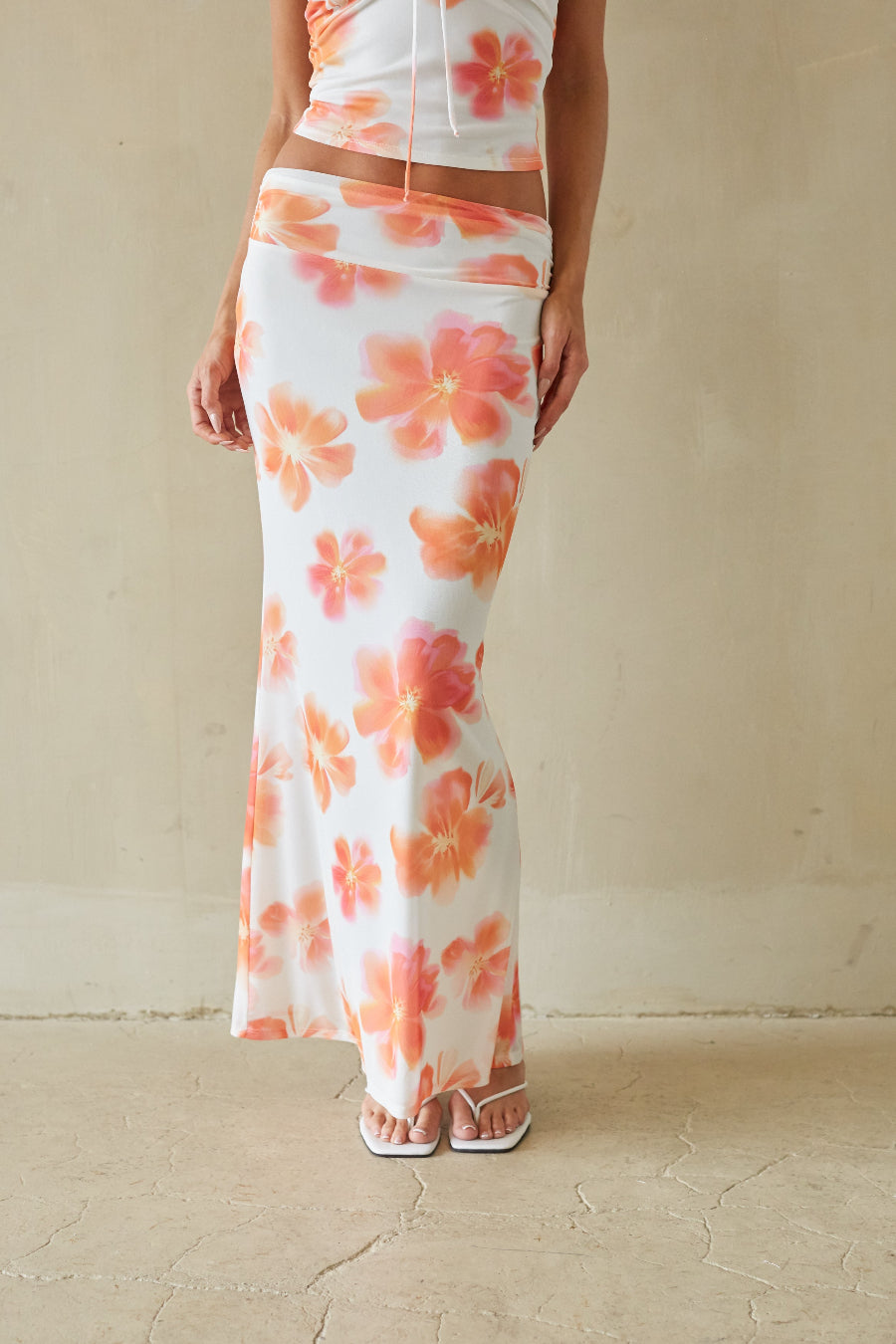 Person wearing a floral dress with a plain background